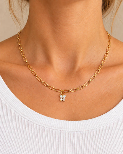 Goldene Livia Gliederkette mit kleinem Charm-Anhänger, am Hals einer Frau mit weißem Oberteil getragen – Stylingbeispiel
