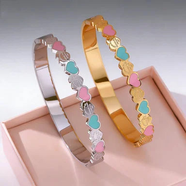 Zwei Titanstahl-Armreifen "Lottie" in Gold und Silber mit bunten Emaille-Herzen (Rosa/Grün)