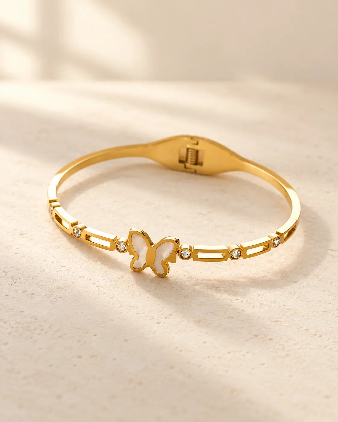 Lunelle wasserfester Schmetterling Armreif in Gold auf hellem Hintergrund