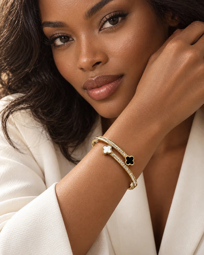 Gold-tone clover bangle with cubic zirconia worn on a wrist