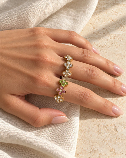 Goldfarbener Mila Blumenring mit bunten Zirkonia-Blüten an einer Hand auf hellem Stoff