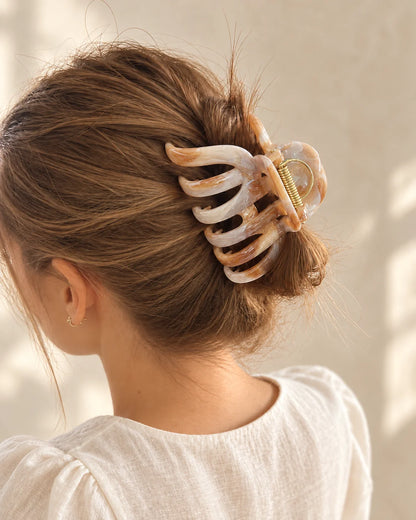 Beige-braune Mira Haarkralle hält einen lockeren Dutt, von hinten fotografiert