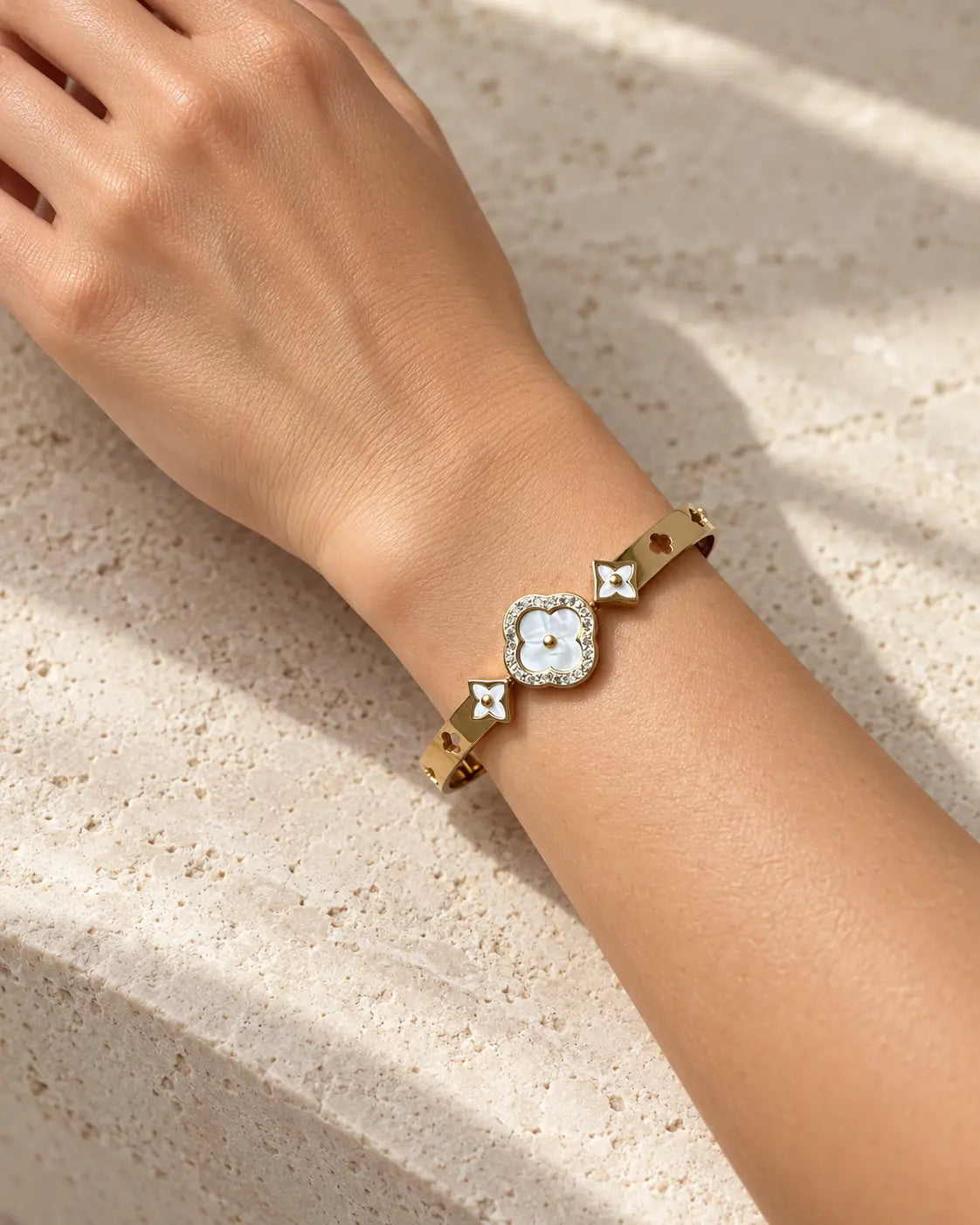 Goldener Muschelblumen Armreif mit Zirkonia am Handgelenk getragen