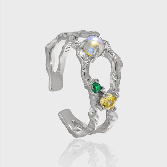 Offener Damenring aus 925er Silber mit leuchtendem Mondstein und bunten Zirkonia, präsentiert auf AURAGLEAM-Karte – elegantes, kunstvolles Design