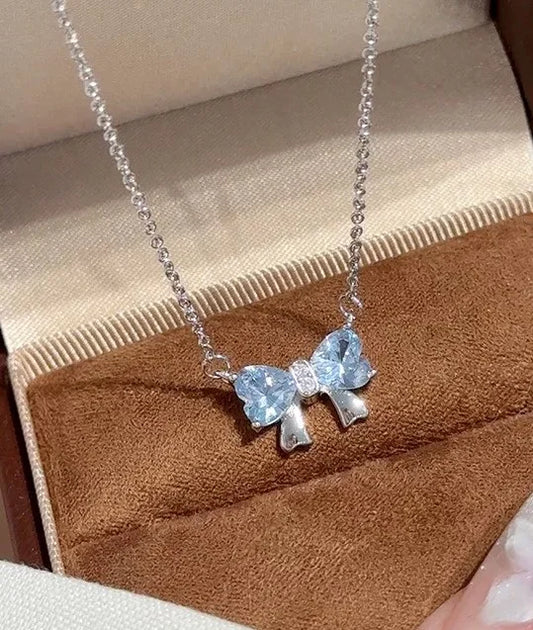 Silberne Halskette mit Anhänger in Schleifenform aus zwei blauen herzförmigen Steinen