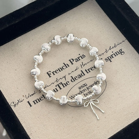 Handgefertigtes Armband aus 925er Silber mit schimmernden Katzenaugenperlen und Schleifenanhänger – elegant und verspielt