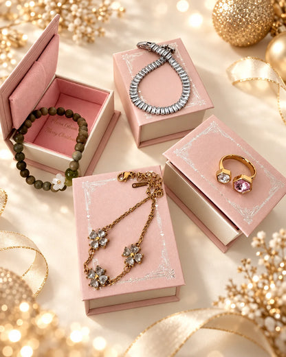 Vier beispielhafte Schmuckstücke auf rosa Geschenkboxen, darunter Armbänder und ein Ring