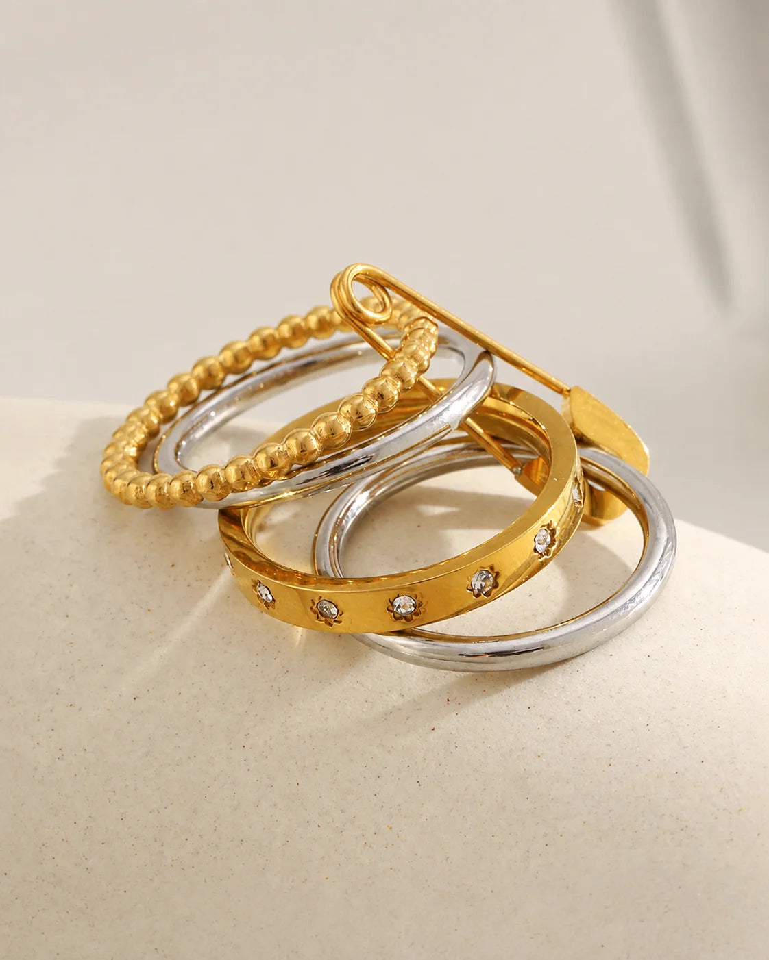 Vergoldeter Layering Ring mit Sicherheitsnadel Design und silberfarbenen Akzenten
