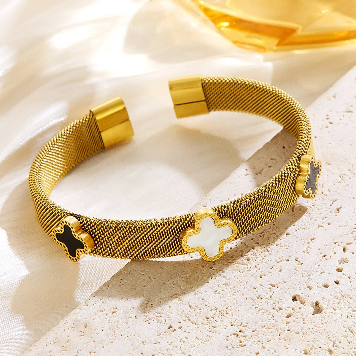18k vergoldeter Mesh-Armreif "Siena" aus Edelstahl mit schwarzen und weißen Kleeblatt-Elementen