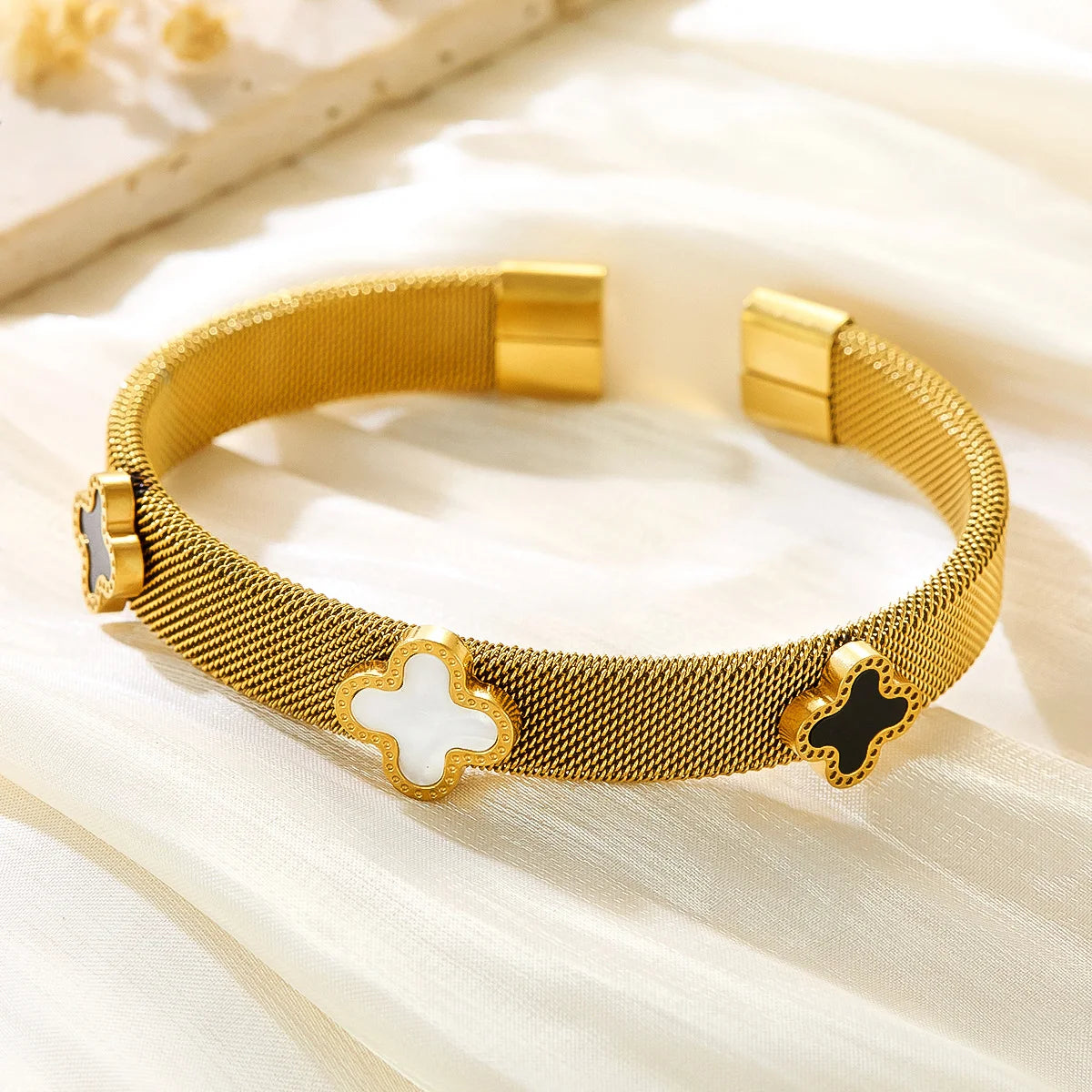 18k vergoldeter Mesh-Armreif "Siena" aus Edelstahl mit schwarzen und weißen Kleeblatt-Elementen