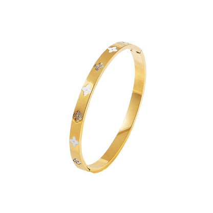 Vergoldeter Edelstahlarmreif mit weißen Blüten und Zirkoniasteinen