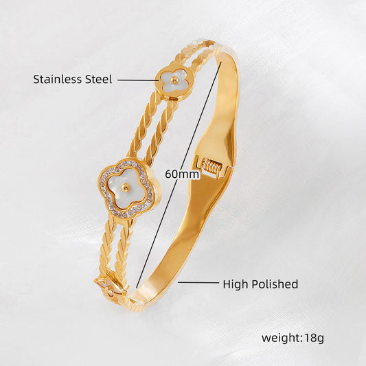 Vergoldeter Edelstahl-Armreif mit gedrehter Struktur und Perlmuttblüten