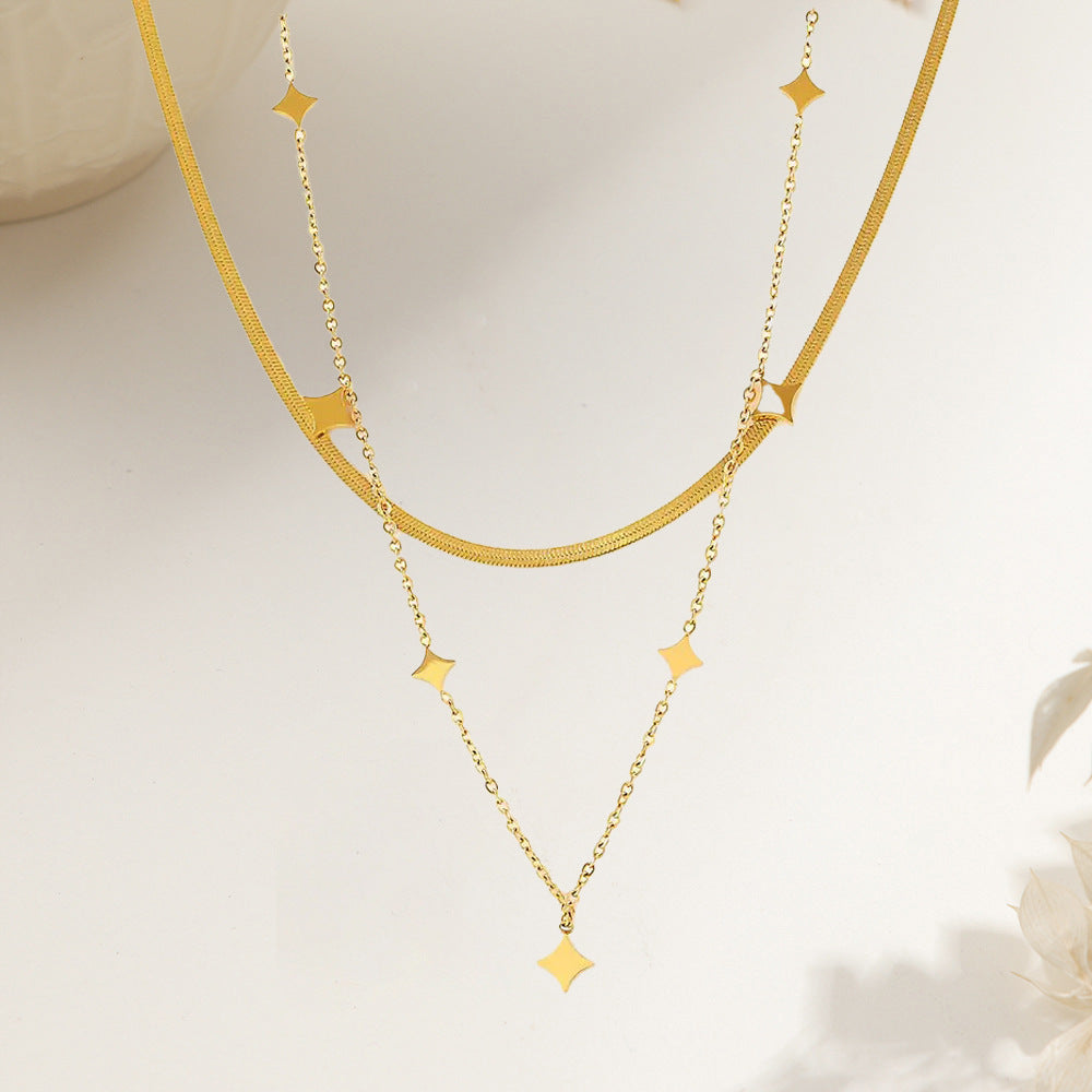 Vergoldete doppellagige Halskette mit kleinen Sternanhängern und glänzendem Finish im modischen Layering-Stil.