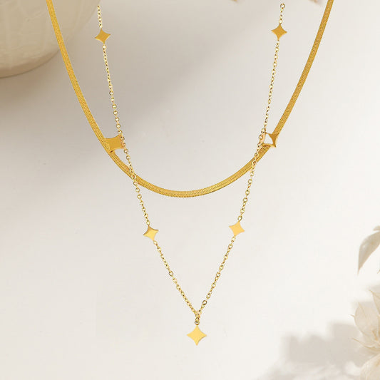 Vergoldete doppellagige Halskette mit kleinen Sternanhängern und glänzendem Finish im modischen Layering-Stil.