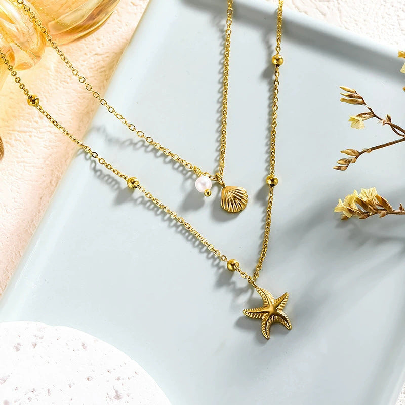 Vergoldete doppellagige Halskette mit Seestern- und Muschelanhänger im maritimen Design.