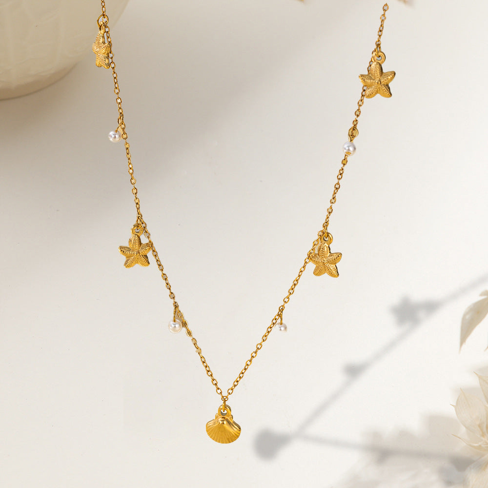 Vergoldete Halskette mit Muschelanhänger, Seesternen und kleinen Perlen im sommerlichen Maritim-Stil.