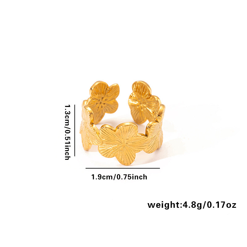 Vergoldeter Edelstahlring mit vierblättrigen Kleeblättern und strukturierter Oberfläche