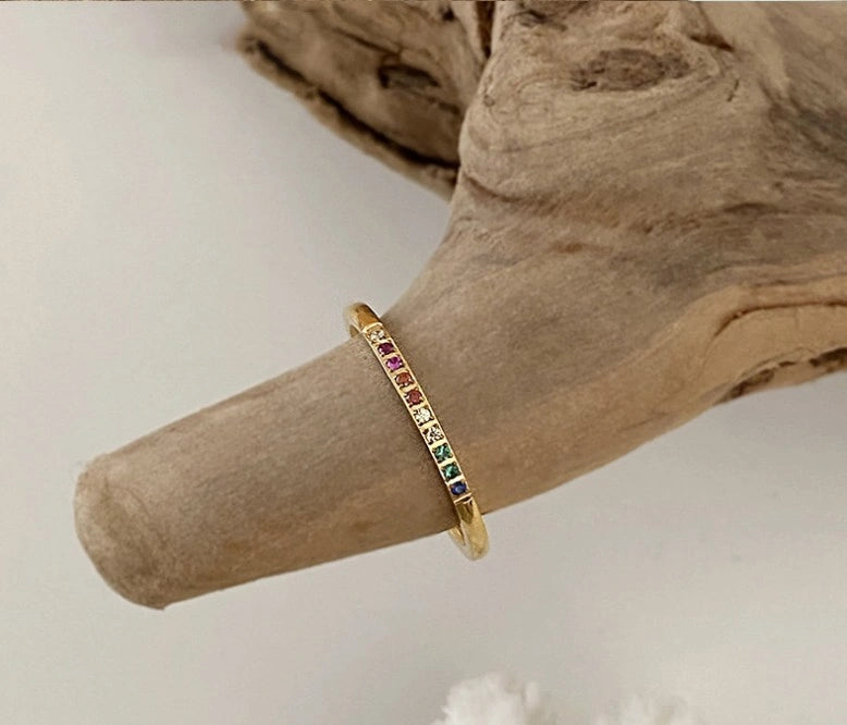 Zwei vergoldete Ringe mit bunten Steinen auf einem Finger – offenes Design, stapelbar.