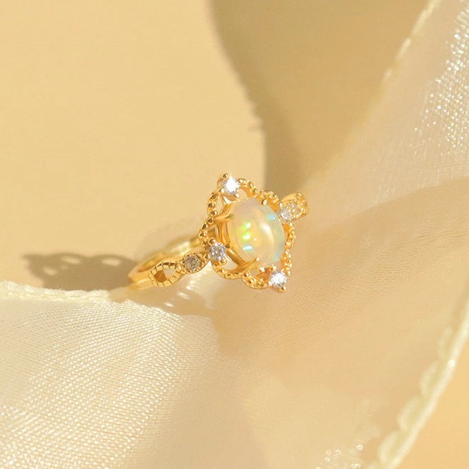 Verstellbarer vergoldeter Ring mit ovalem natürlichen Opal auf weiblicher Hand.