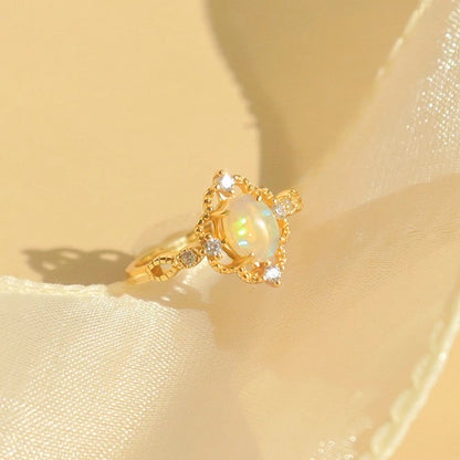 Verstellbarer vergoldeter Ring mit ovalem natürlichen Opal auf weiblicher Hand.