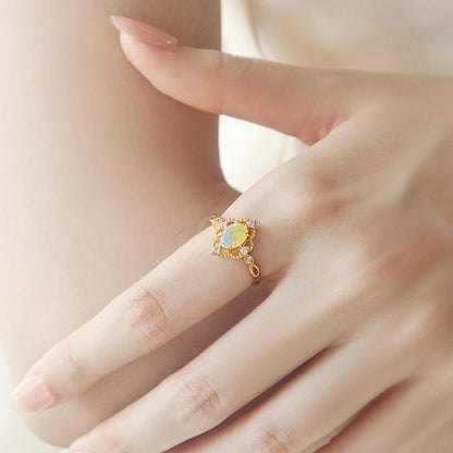 Verstellbarer vergoldeter Ring mit ovalem natürlichen Opal auf weiblicher Hand.