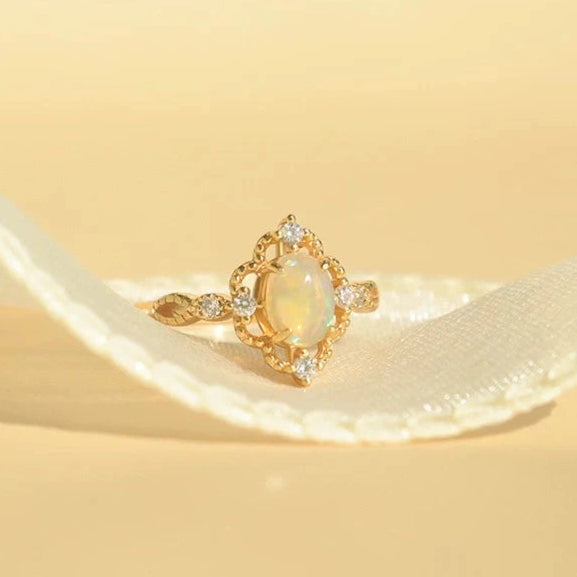 Verstellbarer vergoldeter Ring mit ovalem natürlichen Opal auf weiblicher Hand.