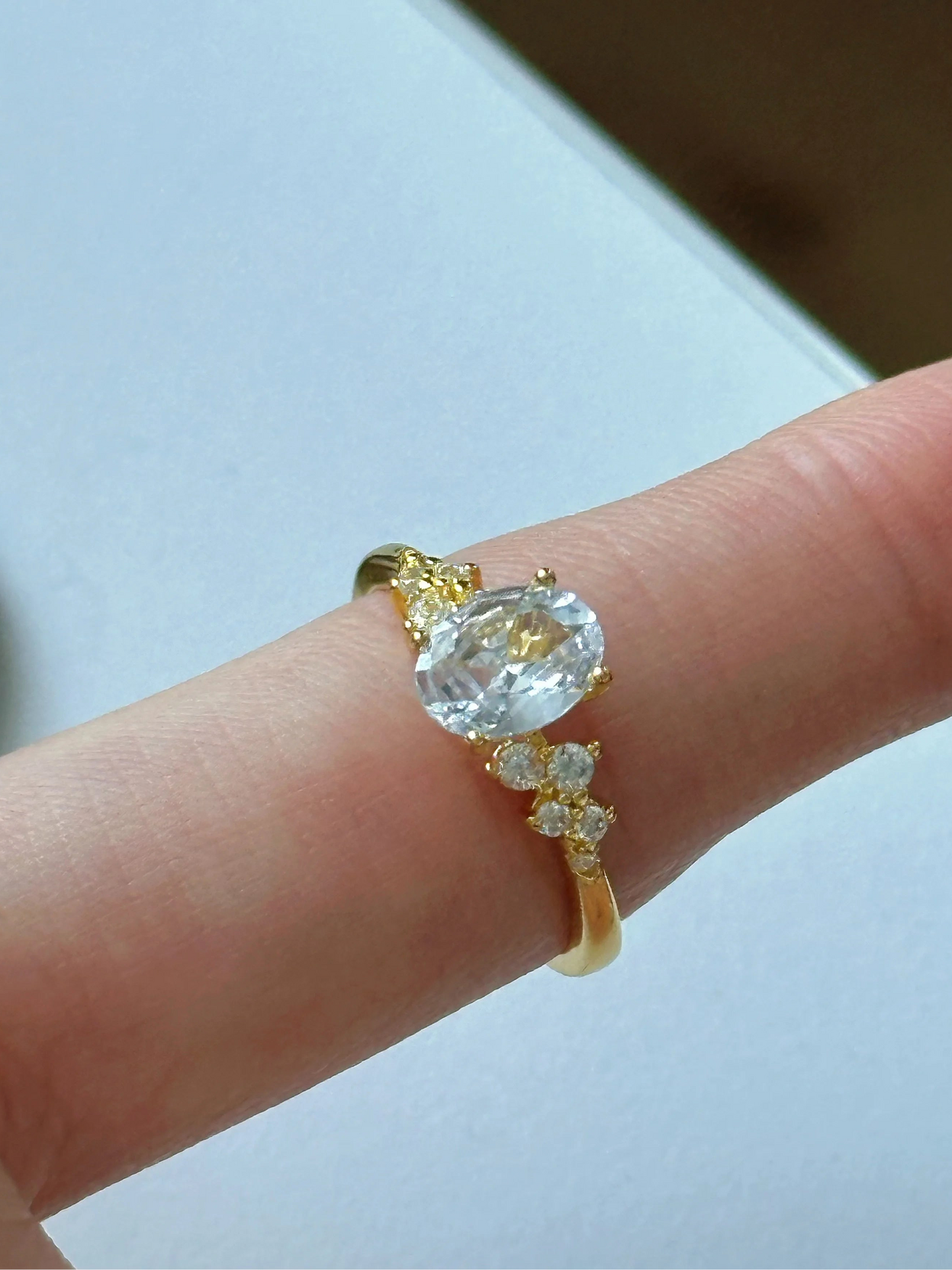 Goldener Ring mit großem funkelnden ovalen Zirkonia und seitlichen Steinen