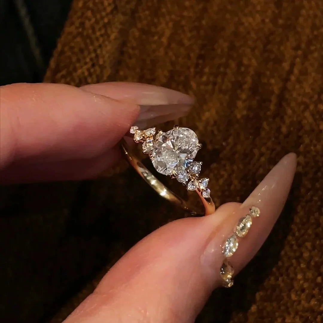 Goldener Ring mit großem funkelnden ovalen Zirkonia und seitlichen Steinen