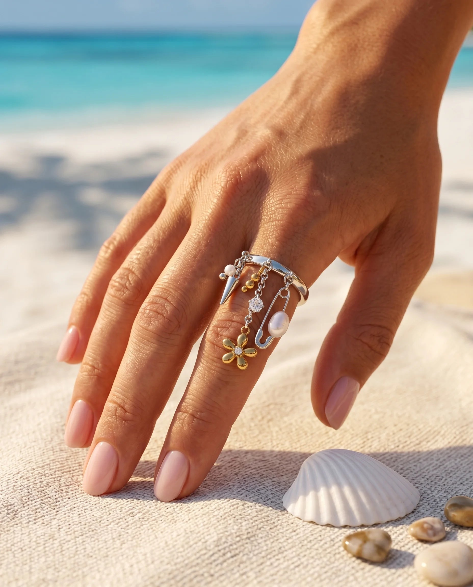 Silberner Ring aus Titanstahl mit verschiedenen baumelnden Charms wie einer Sicherheitsnadel, Perlen, einem Spike und einer 18K vergoldeten Blume