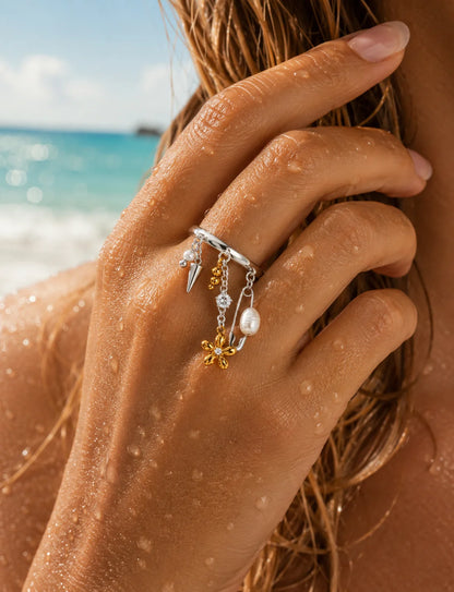 Silberner Ring aus Titanstahl mit verschiedenen baumelnden Charms wie einer Sicherheitsnadel, Perlen, einem Spike und einer 18K vergoldeten Blume