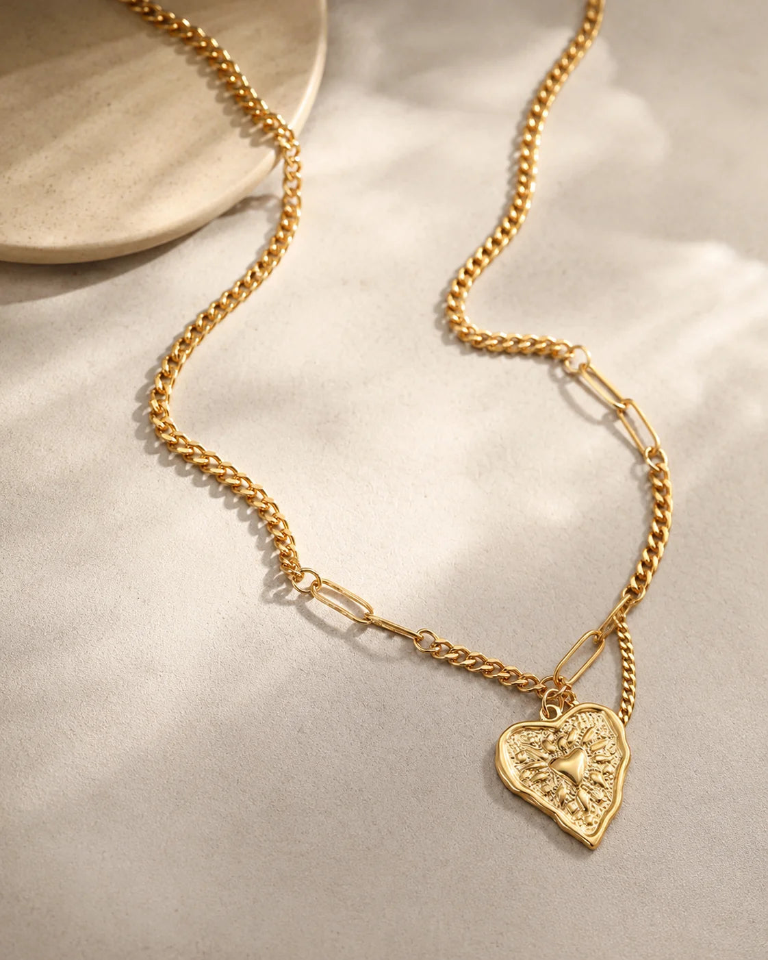 Goldene Halskette aus 18K vergoldetem Titanstahl im asymmetrischen Kettendesign mit einem gehämmerten Vintage-Herz-Anhänger