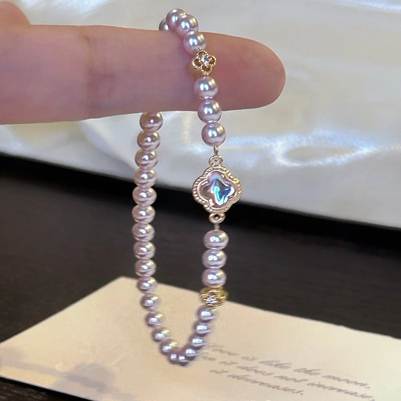 Elegantes Viona's Irisierendes Kleeblatt Armband aus rosig-weißen Kunstperlen mit goldenen Details und Glücksbringer-Anhänger