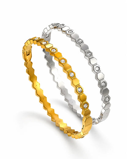 Eleganter Waben-Brillanz Armreif aus Titanstahl in Gold und Silber mit geometrischem Hexagon-Muster und funkelnden Zirkonia-Steinen