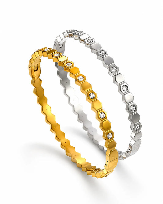 Eleganter Waben-Brillanz Armreif aus Titanstahl in Gold und Silber mit geometrischem Hexagon-Muster und funkelnden Zirkonia-Steinen