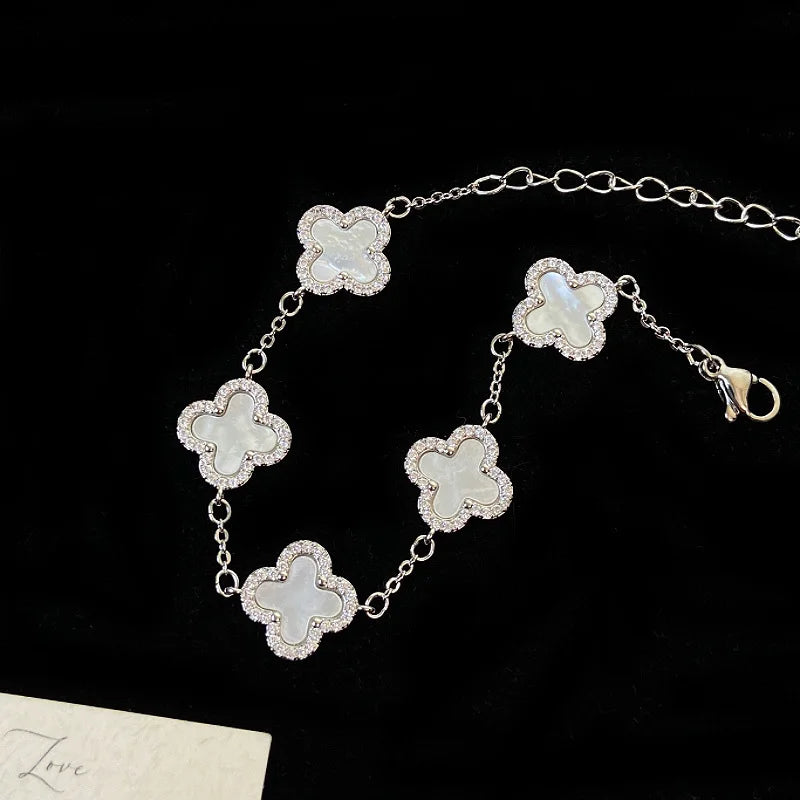 Elegantes versilbertes Armband mit fünf Kleeblatt-Motiven, verziert mit weißer Perlmutt-Optik und Zirkonia-Rand