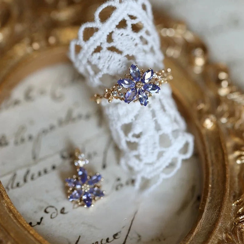 Goldener Ring mit lila Zirkonia Schneeflocke an einer Frauenhand