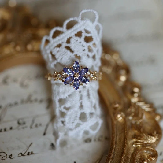 Goldener Ring mit lila Zirkonia Schneeflocke an einer Frauenhand