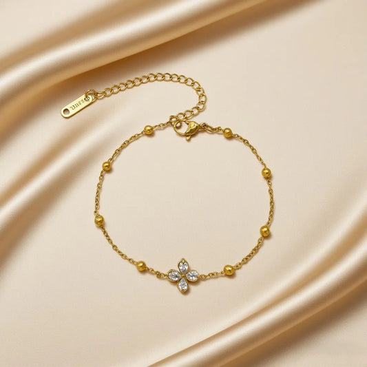 Zartes Blüten-Glanz Armband aus vergoldetem Titanstahl mit Zirkonia-Blüte und Goldperlen auf goldenem Satin