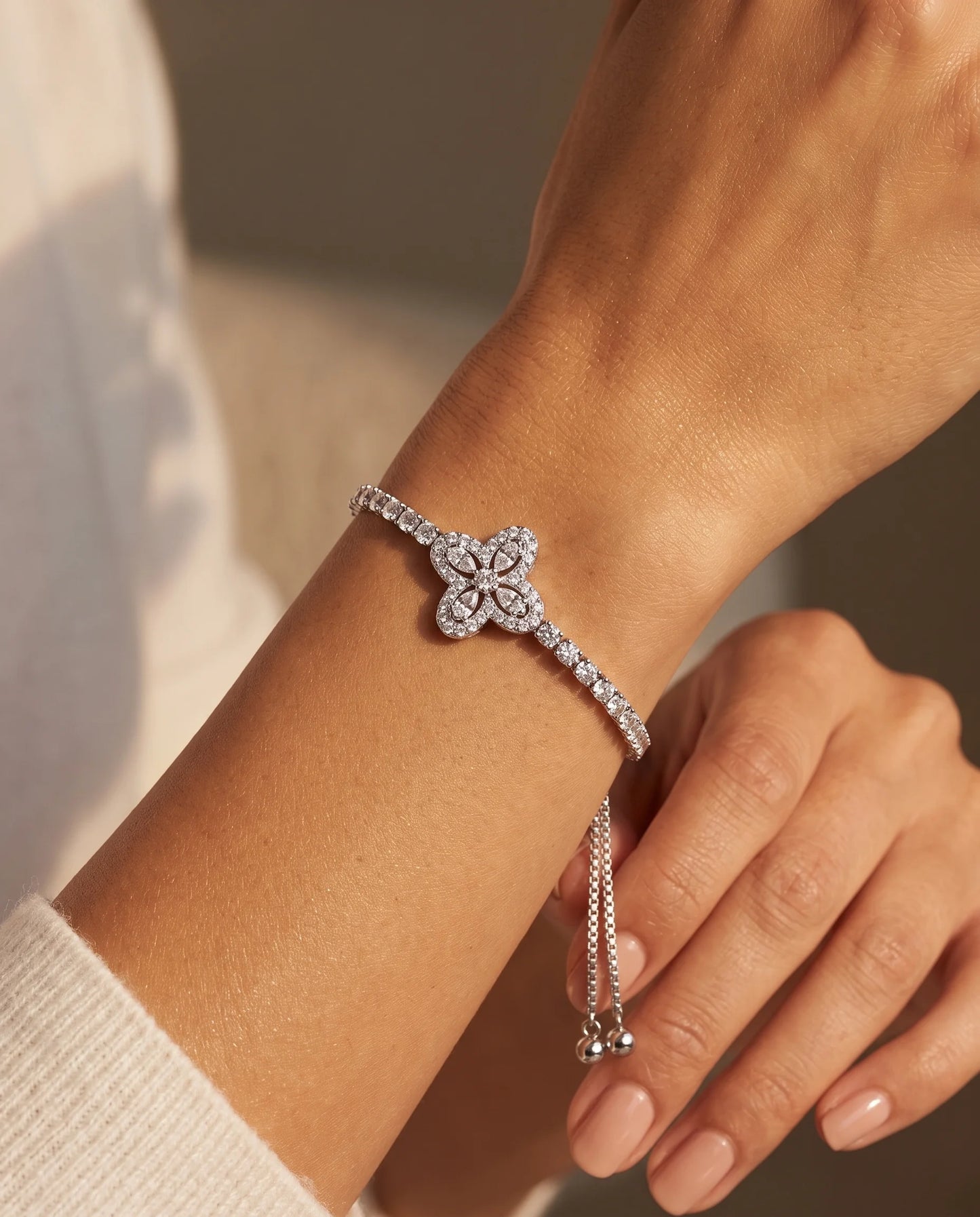 Verstellbares Zirkonia Kleeblatt Armband für Damen aus versilbertem Kupfer mit Zugverschluss auf weißem Hintergrund