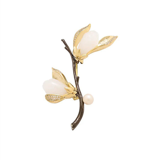 Elegante Magnolien-Brosche mit goldfarbenen Blütenblättern, Zirkoniabesatz und einer zarten Süßwasserperle – femininer Natur-Schmuck im asiatischen Stil