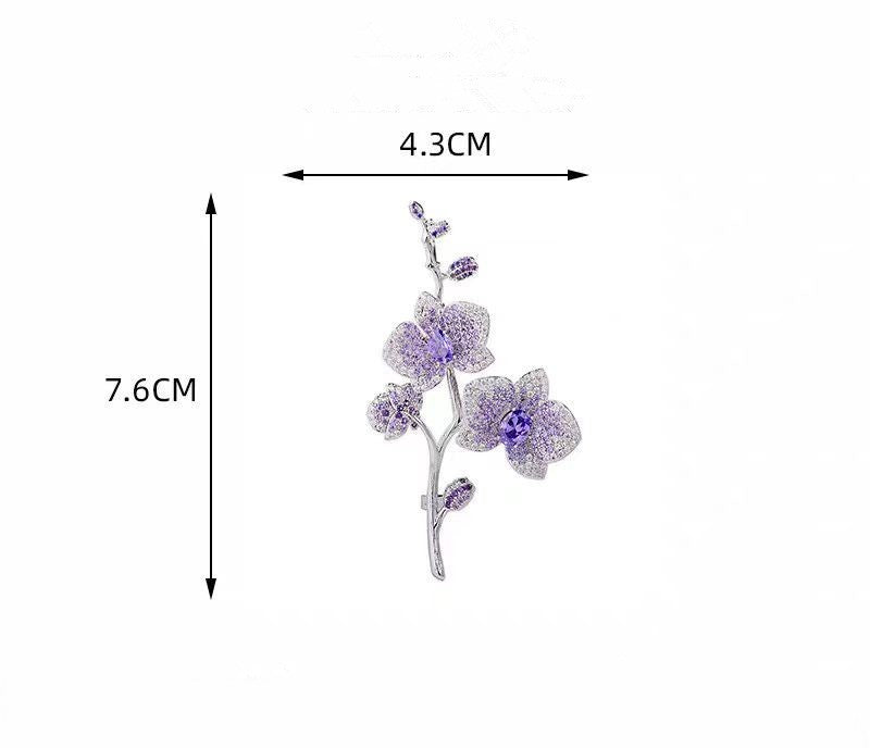 Elegante Orchideen-Brosche mit lila Zirkonia und Blütenmotiv auf silbernem Zweig